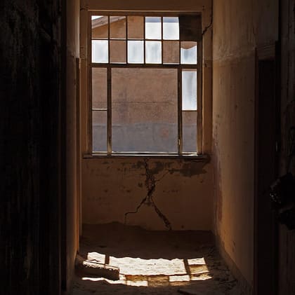 Fenster mit Sprossen und Sand davor