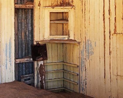 Verwitterte Holzwand mit Bord und Klappe