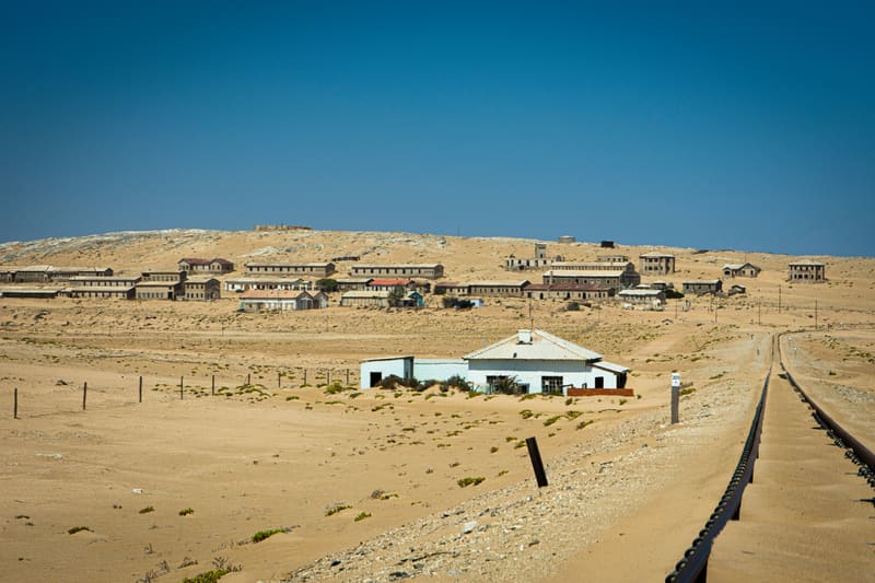 Blick über die Häuser von Kolmanskop mit der Bahnlinie im Vordergrund